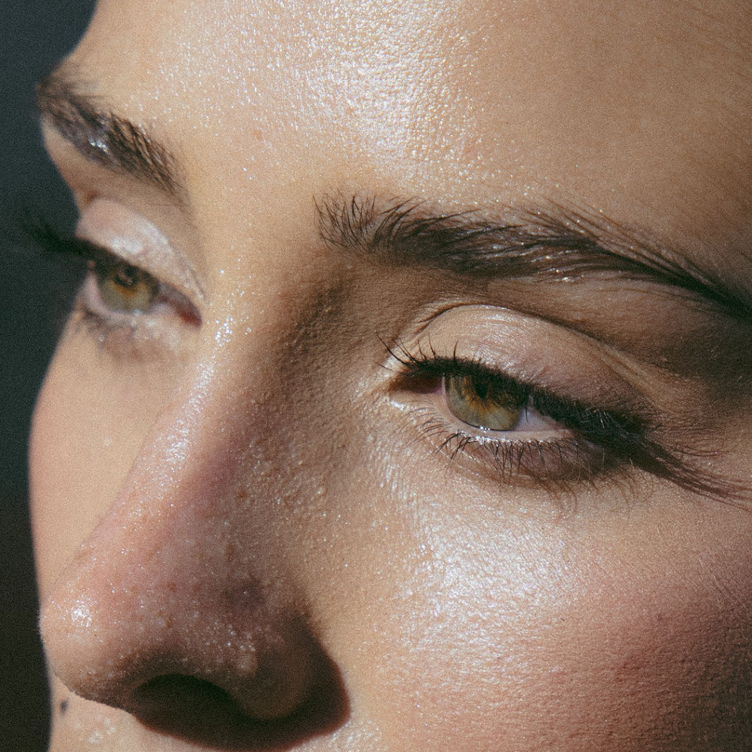Close-up of a woman’s face with clear, glowing skin, highlighting the benefits of clean, natural skincare. Her complexion appears radiant and healthy, emphasizing the importance of avoiding harmful skincare ingredients.